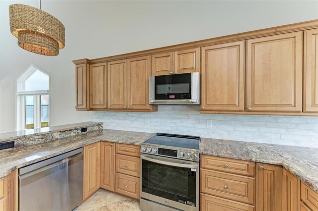 kitchen with appliances with stainless steel finishes, tasteful backsplash, and light stone countertops