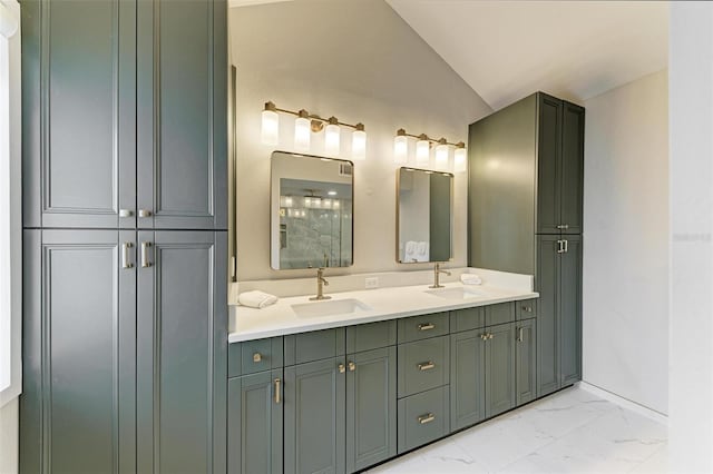 bathroom with vaulted ceiling, marble finish floor, double vanity, and a sink