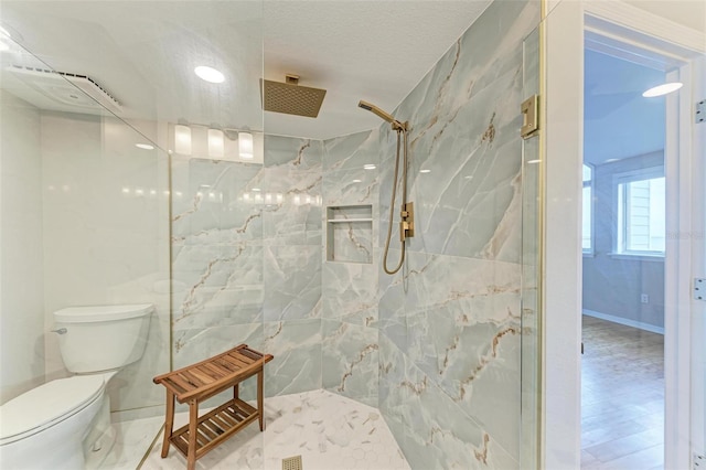 full bath with a textured ceiling, a marble finish shower, toilet, and baseboards