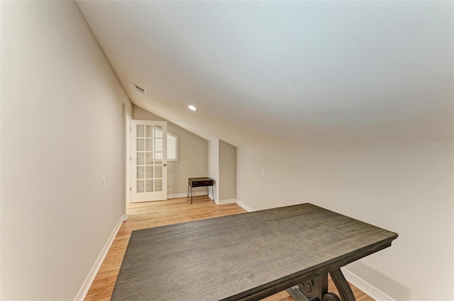 interior space featuring light wood finished floors, recessed lighting, visible vents, vaulted ceiling, and baseboards