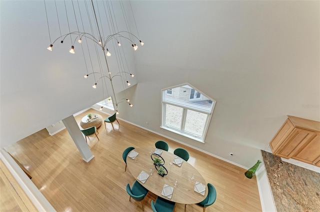 exercise room featuring a high ceiling, baseboards, and wood finished floors