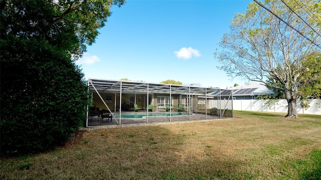 view of yard featuring a fenced in pool and glass enclosure