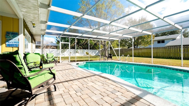 view of pool with a patio area and glass enclosure