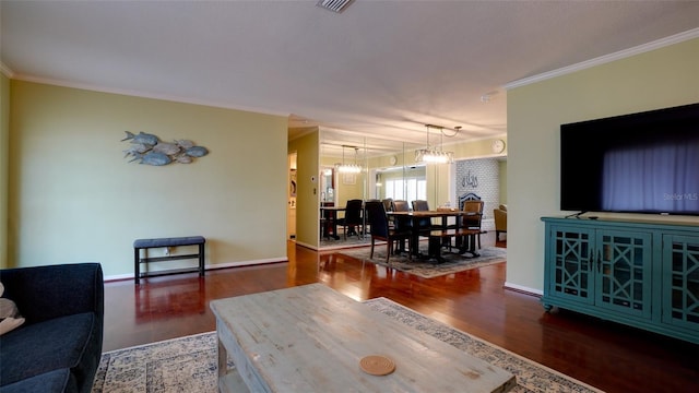 living room with ornamental molding, dark hardwood / wood-style floors, and an inviting chandelier