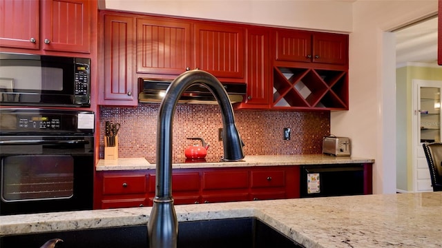 kitchen with backsplash, light stone countertops, and black appliances