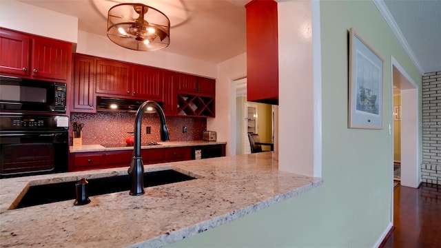 kitchen featuring crown molding, backsplash, light stone counters, black appliances, and a chandelier