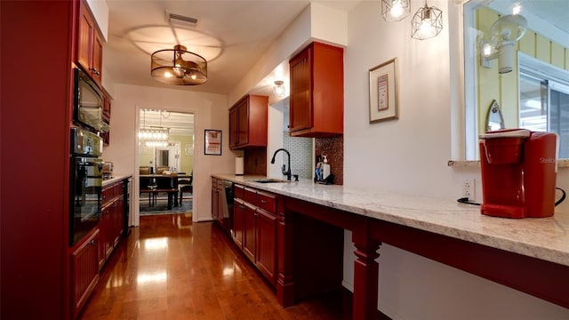 kitchen featuring sink, light stone counters, tasteful backsplash, black appliances, and dark hardwood / wood-style flooring