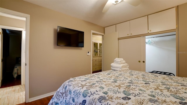 bedroom featuring dark wood-type flooring, a closet, and ceiling fan