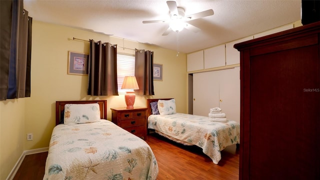 bedroom with hardwood / wood-style floors, a textured ceiling, and ceiling fan