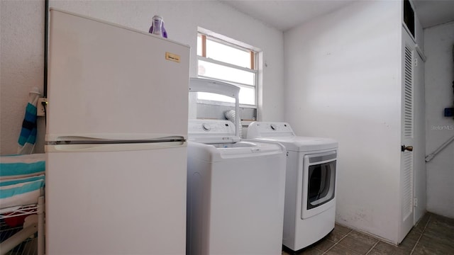 laundry area featuring separate washer and dryer and dark tile patterned flooring