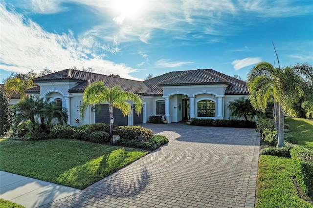 mediterranean / spanish-style home featuring a garage and a front yard