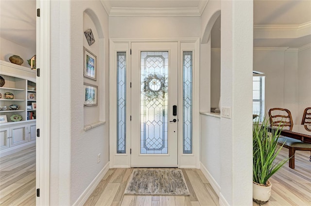 foyer entrance featuring ornamental molding and light wood-type flooring