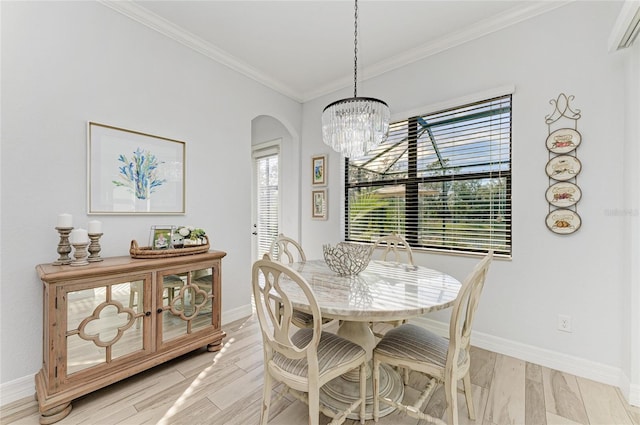 dining space with crown molding, a chandelier, and light wood-type flooring