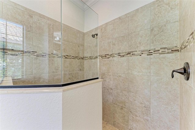 bathroom featuring a tile shower and ornamental molding