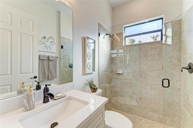 bathroom with vanity, a shower with shower door, and toilet