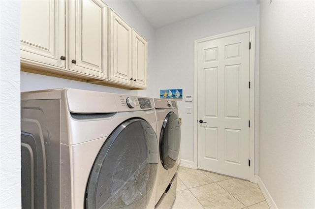 laundry room featuring cabinets, washing machine and clothes dryer, and light tile patterned floors