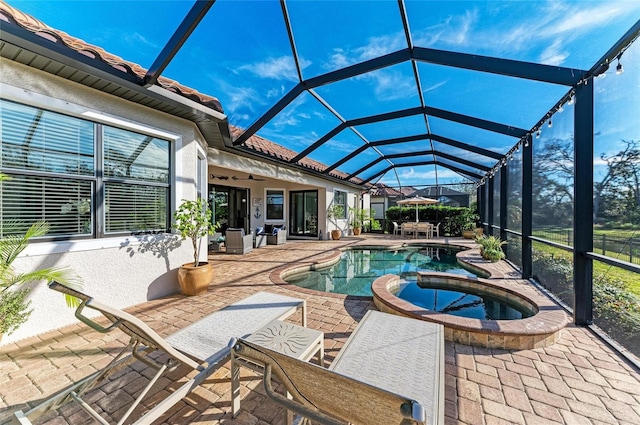 view of swimming pool with a lanai, a patio area, and an in ground hot tub