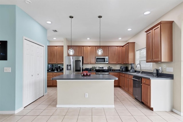 kitchen featuring light tile patterned flooring, sink, hanging light fixtures, a center island, and stainless steel appliances