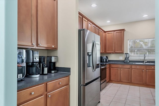 kitchen with stainless steel appliances, sink, and light tile patterned floors