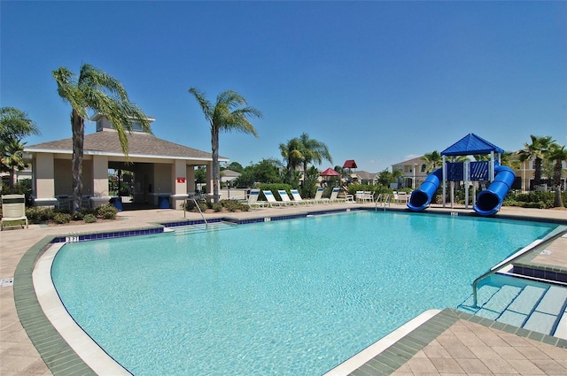 view of pool featuring a playground and a water slide