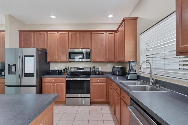 kitchen with sink, light tile patterned floors, and appliances with stainless steel finishes