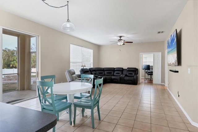 tiled dining space with ceiling fan