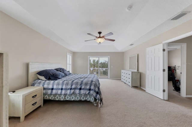 bedroom with ceiling fan, light colored carpet, access to exterior, and a raised ceiling