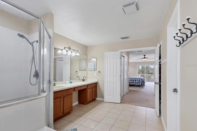 bathroom with walk in shower, tile patterned floors, vanity, and a textured ceiling