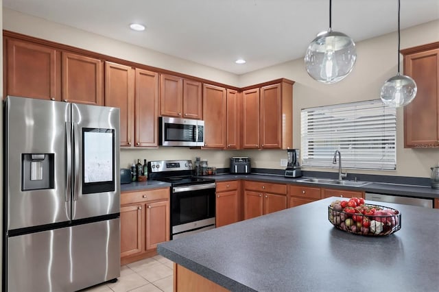 kitchen featuring sink, stainless steel appliances, hanging light fixtures, and light tile patterned flooring