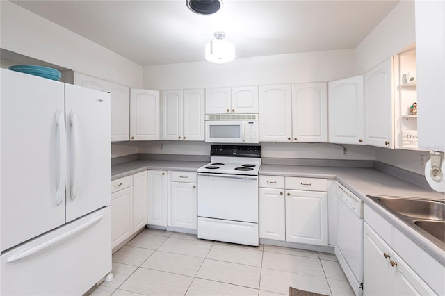 kitchen featuring white cabinetry, sink, white appliances, and light tile patterned floors