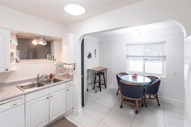 kitchen with sink, white cabinets, dishwasher, and light tile patterned floors