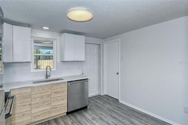 kitchen with white cabinetry, light hardwood / wood-style flooring, sink, stainless steel dishwasher, and a textured ceiling