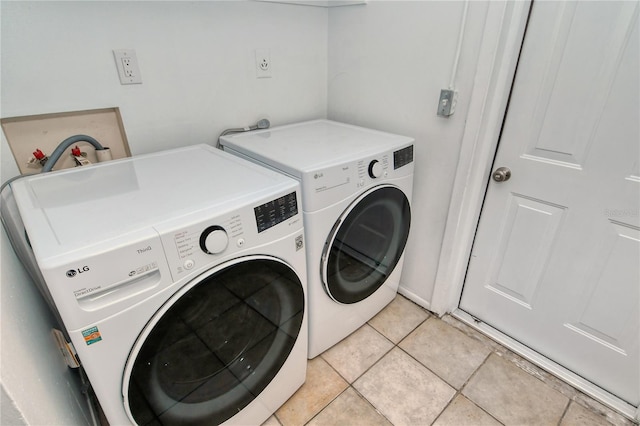 laundry room featuring light tile patterned flooring and washer and clothes dryer