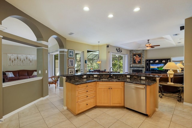 kitchen with dishwasher, a kitchen island with sink, sink, and dark stone counters