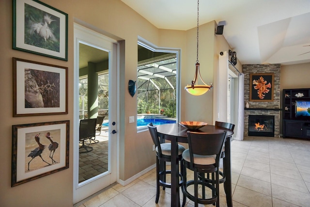 tiled dining room with a stone fireplace