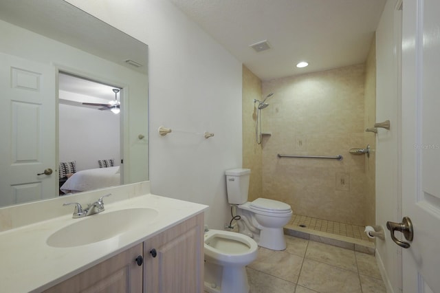 bathroom with vanity, a tile shower, tile patterned floors, and toilet