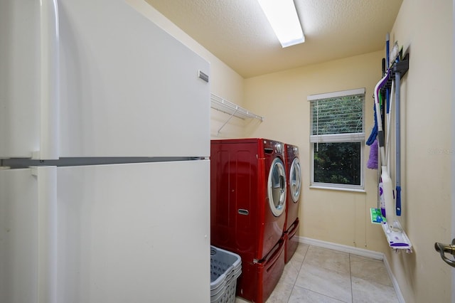 laundry room with light tile patterned floors, washer and clothes dryer, and a textured ceiling