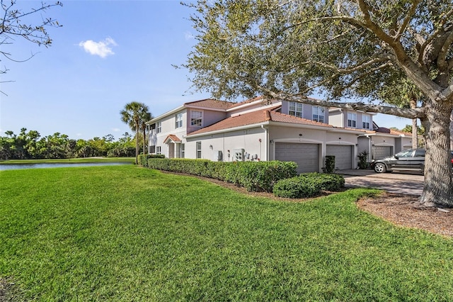 view of side of property featuring a yard, a garage, and a water view