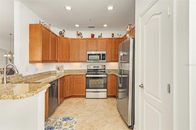 kitchen featuring sink, hanging light fixtures, light tile patterned floors, appliances with stainless steel finishes, and kitchen peninsula