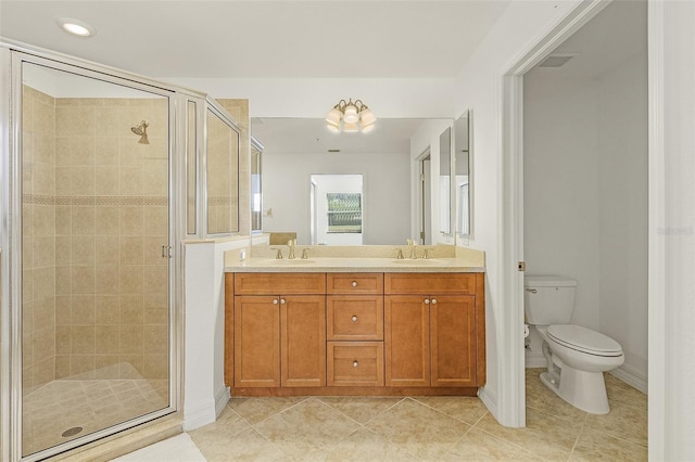 bathroom with vanity, toilet, tile patterned flooring, and a shower with door