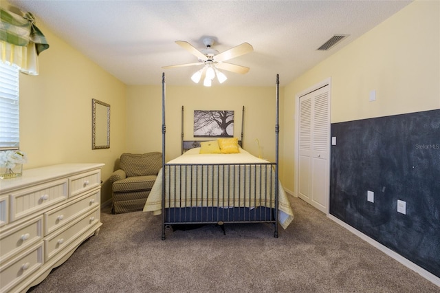 bedroom with a closet, ceiling fan, carpet flooring, and a textured ceiling