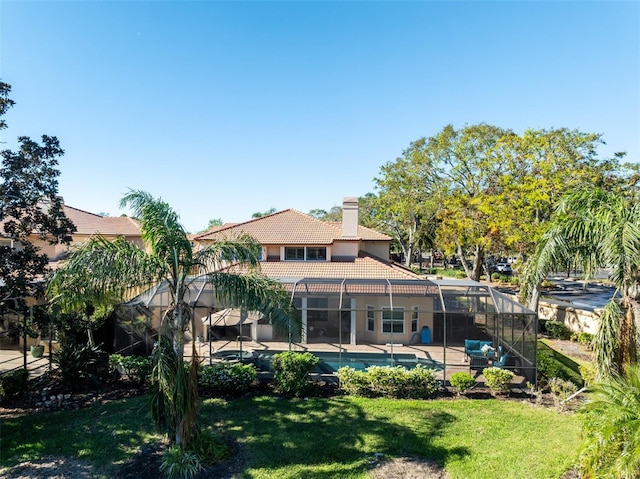 rear view of property featuring glass enclosure, a lawn, and a patio