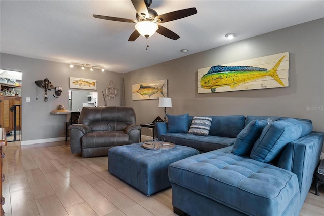 living room with light hardwood / wood-style floors and ceiling fan