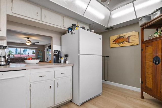 kitchen with white appliances, white cabinets, ceiling fan, and light hardwood / wood-style floors