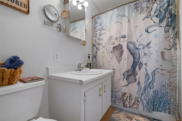 bathroom with a shower with curtain, toilet, and vanity