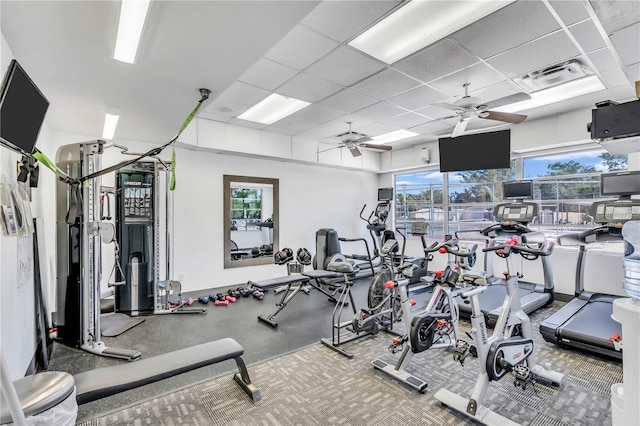 gym with a paneled ceiling and ceiling fan