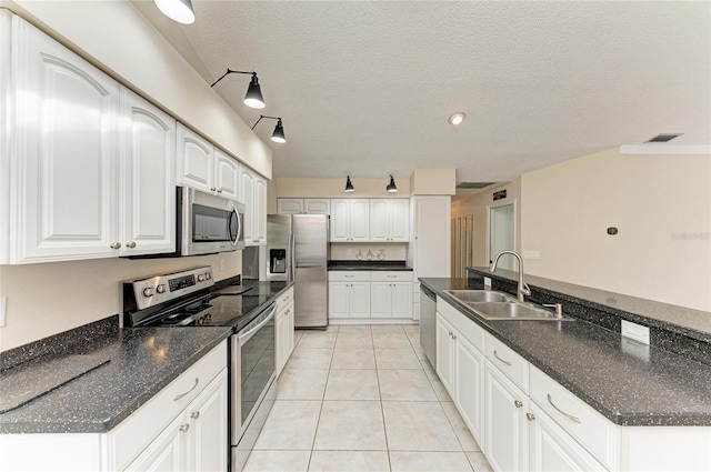 kitchen with white cabinetry, appliances with stainless steel finishes, sink, and light tile patterned floors