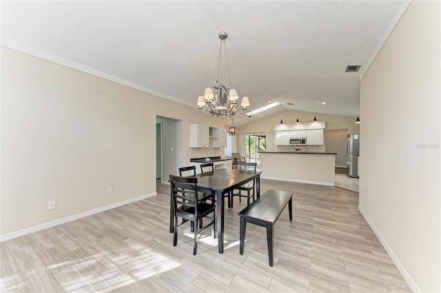 dining area featuring lofted ceiling, light wood-type flooring, a notable chandelier, and a textured ceiling