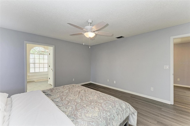 bedroom featuring connected bathroom, hardwood / wood-style floors, a textured ceiling, and ceiling fan