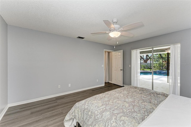 bedroom featuring dark hardwood / wood-style flooring, access to exterior, a textured ceiling, and ceiling fan